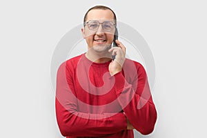 Happy young man using mobile phone, isolated on gray background