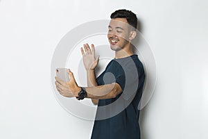 Happy young man using mobile phone isolated on white background