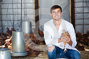 Happy young man veterinarian with chicken