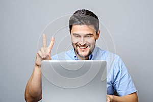 Happy young man video chatting on laptop computer