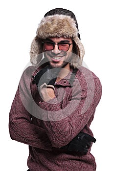 Happy young man in warm sweater and fur hat