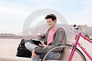 Happy young man watching video on tablet outdoors