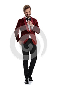 Happy young man wearing red velvet tuxedo and black bowtie