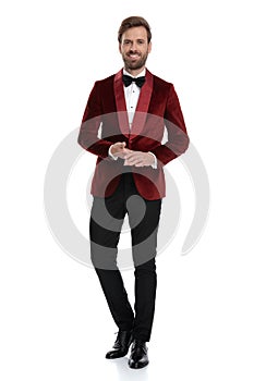 Happy young man wearing red velvet tuxedo and black bowtie