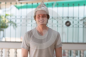 Happy young man wearing tin foil hat as conspiracy theory concept outdoors