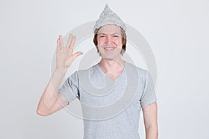 Happy young man wearing tin foil hat as conspiracy theory concept showing Vulcan salute in Star Trek