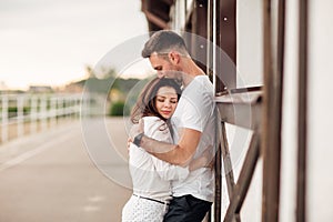 Happy young man and woman having fun outdoors on a warm summer day. couple is hugging near horse rancho