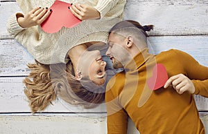 Happy young man and woman in love lying on floor during photo session on Valentine& x27;s Day