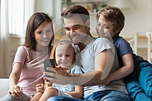 Happy young man making selfie shot with wife and children.