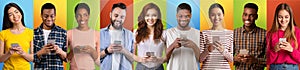 Happy young men and women using smartphones while standing over colorful backgrounds