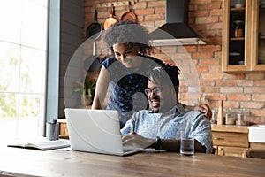 Happy young mixed race african family couple using computer.