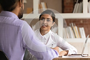 Happy young mixed race colleagues discussing business ideas.