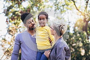 Happy young mixed race couple spending time with their daughter