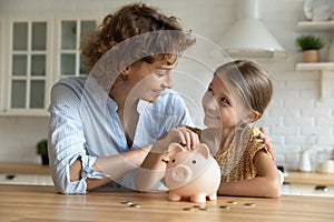 Happy young mom and daughter saving for future