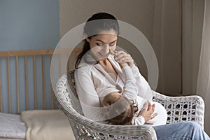 Happy young mom enjoying breastfeeding baby, motherhood, emotional bonding