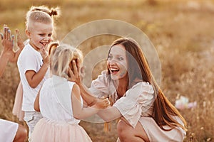 Happy young moms playing with their kids outdoors in summer. Happy family time together concept. selective focus