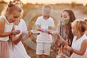 Happy young moms playing with their kids outdoors in summer. Happy family time together concept. selective focus