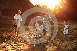 Happy young moms playing with their kids outdoors in summer. Happy family time together concept. selective focus