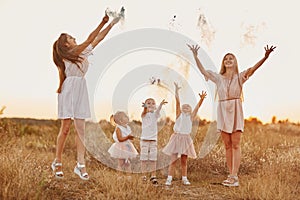 Happy young moms playing with their kids outdoors in summer. Happy family time together concept. selective focus