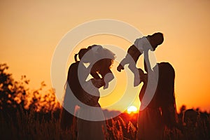 Happy young moms playing with their kids outdoors in summer. Happy family time together concept. selective focus