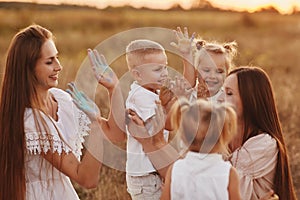 Happy young moms playing with their kids outdoors in summer. Happy family time together concept. selective focus