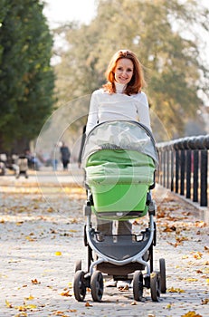 Happy young mother with baby in buggy