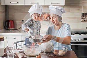 happy young mother and child preparing dough for baking