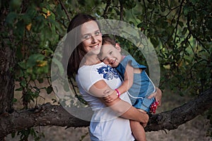 Happy young mother with children. A beautiful young woman hugs her laughing daughter