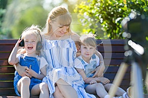 Happy young mother with children in front of a video camera