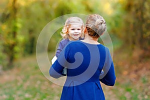 Happy young mother having fun cute toddler daughter, family portrait together. Woman with beautiful baby girl in nature