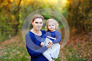 Happy young mother having fun cute toddler daughter, family portrait together. Woman with beautiful baby girl in nature