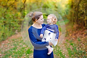 Happy young mother having fun cute toddler daughter, family portrait together. Woman with beautiful baby girl in nature