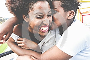 Happy young mother having fun with her child in summer day - Son kissing his mum outdoor - Family lifestyle, motherhood, love and