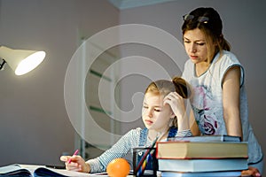 Happy Young Mother Helping Her Daughter While Studying At Home getting ready for school