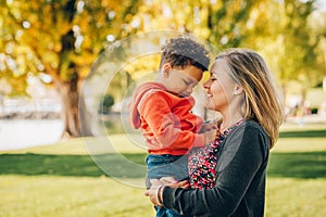 Happy young mother holding sweet toddler boy