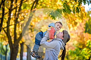 Happy young mother holding sweet toddler boy, family having fun