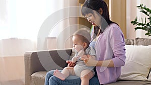 Happy young mother with little baby boy at home