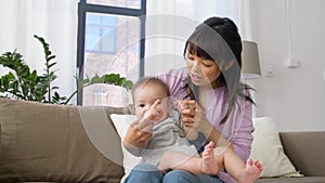 Happy young mother with little baby boy at home