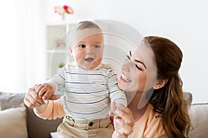 Happy young mother with little baby at home