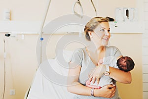 Happy young mother with newborn baby in hospital