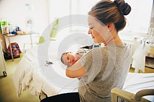 Happy young mother with newborn baby in hospital