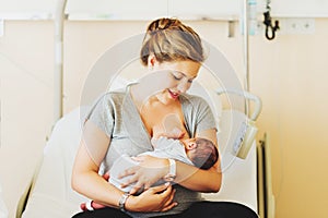 Happy young mother with newborn baby in hospital