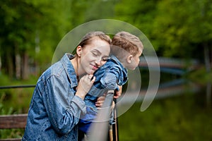 Happy young mother playing and having fun with her little baby son on warm spring or summer day in the park. Happy family concept