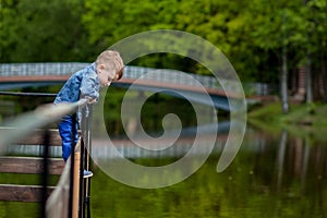 Happy young mother playing and having fun with her little baby son on warm spring or summer day in the park. Happy family concept