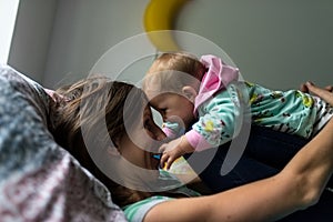 Happy young mother playing with her baby daughter