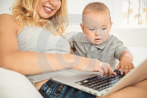 Happy young mother playing with her son the couch