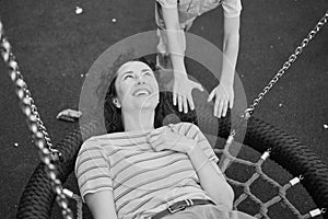 Happy Young mother playing with her son on the playground, hugging, laughing