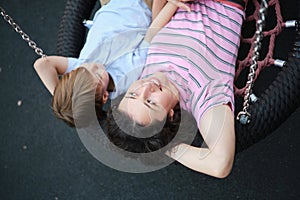 Happy Young mother playing with her son on the playground, hugging, laughing