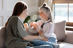 Happy young mother and teen daughter talk at home