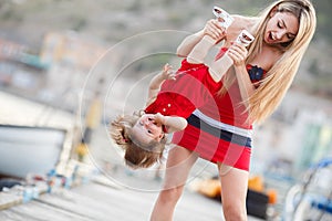 Happy young mother with a young daughter near Yacht Club